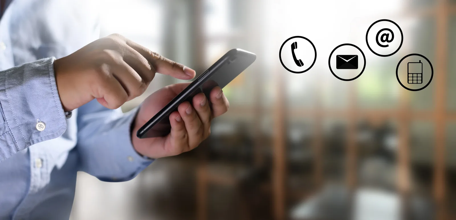 A person using a mobile phone, with telephone, envelope, at-sign and handset icons shown alongside.